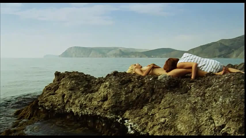 Девушки ласкаются на скалах у моря